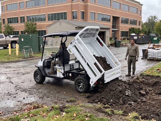 LLAMA Truck with hydraulic dump bed unloading material at a commercial job site